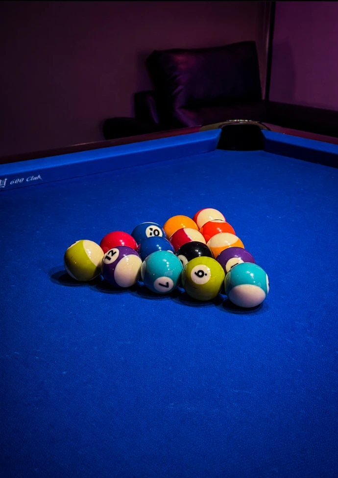 Close-up of colorful pool balls on a blue pool table at Playcation.