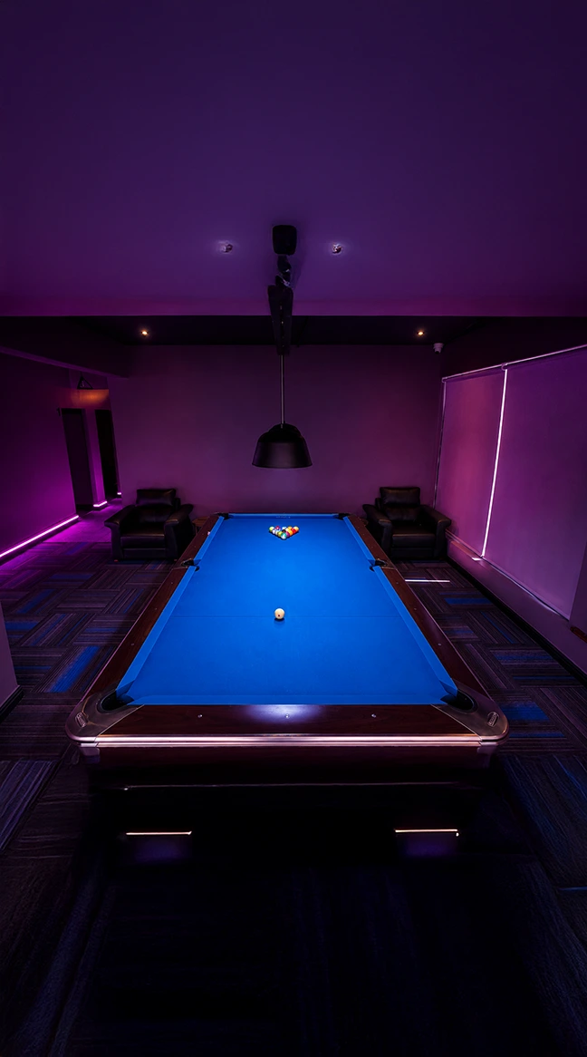 Premium pool table setup with purple lighting and lounge seating at Playcation.